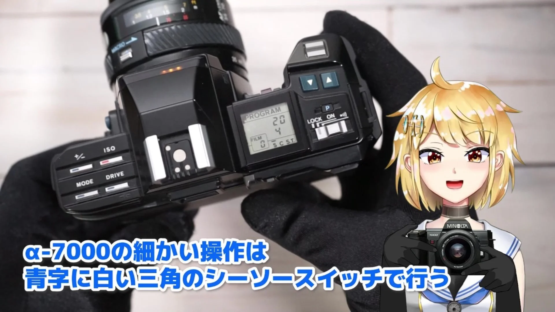 シャッターボタンの手前とレンズの脇にある、青いスイッチ